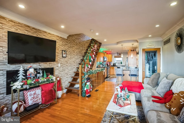 living room with crown molding and light hardwood / wood-style flooring