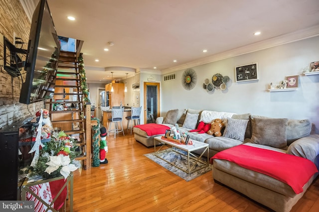 living room featuring wood-type flooring and crown molding