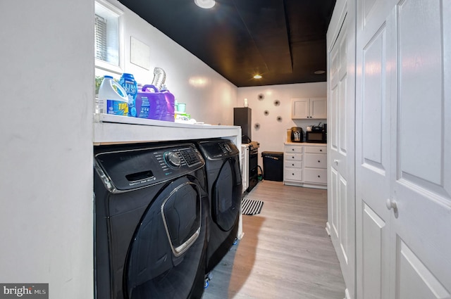 washroom with light hardwood / wood-style flooring and washing machine and clothes dryer