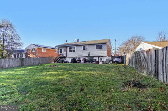 rear view of property with a lawn