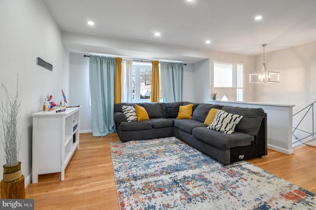 living room with a notable chandelier and light hardwood / wood-style floors