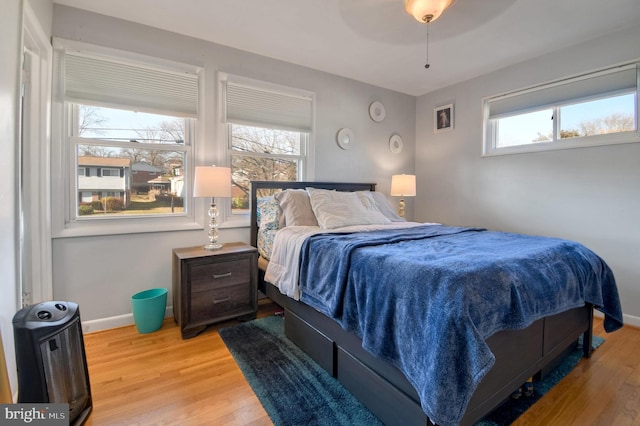 bedroom featuring multiple windows, ceiling fan, and hardwood / wood-style floors