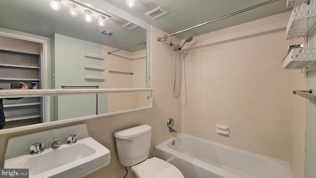 full bathroom featuring washtub / shower combination, toilet, and sink