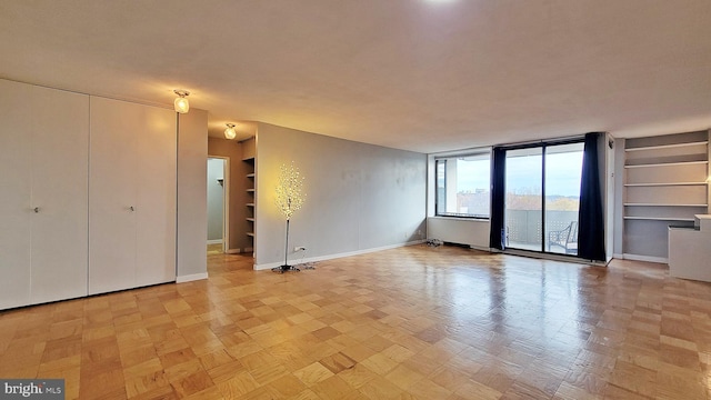 unfurnished room featuring built in shelves