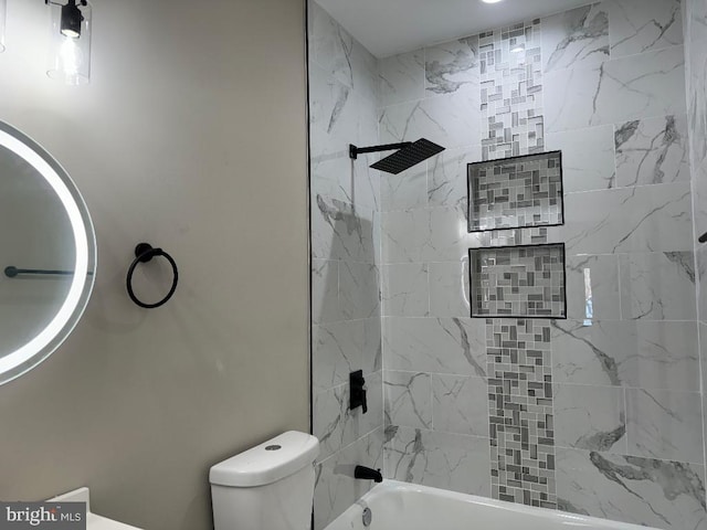 bathroom featuring tiled shower / bath combo and toilet