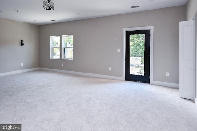 unfurnished room featuring light colored carpet and a wealth of natural light