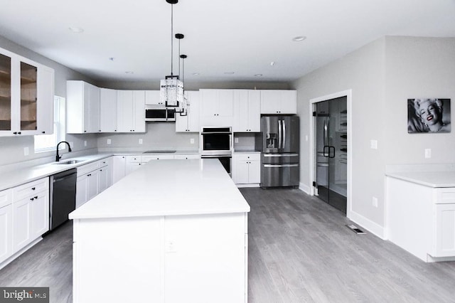 kitchen featuring white cabinetry, pendant lighting, a kitchen island, and black appliances