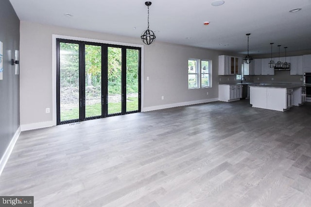 unfurnished living room with hardwood / wood-style floors and sink