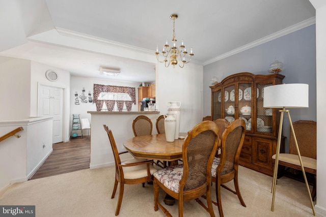 dining space with light hardwood / wood-style flooring, a chandelier, and ornamental molding