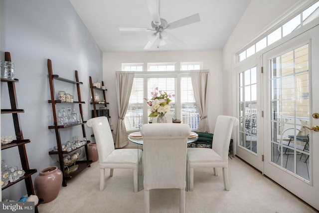 dining area with light carpet, ceiling fan, and lofted ceiling