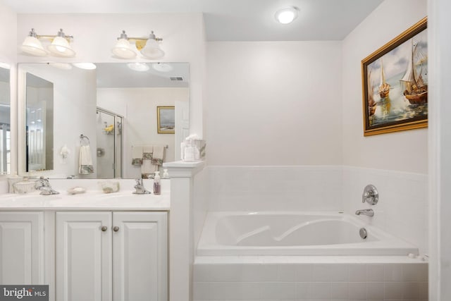 bathroom with tiled bath and vanity