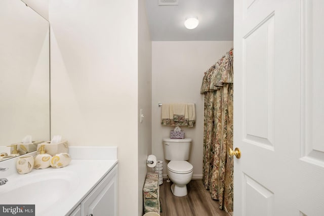 bathroom featuring hardwood / wood-style flooring, vanity, and toilet