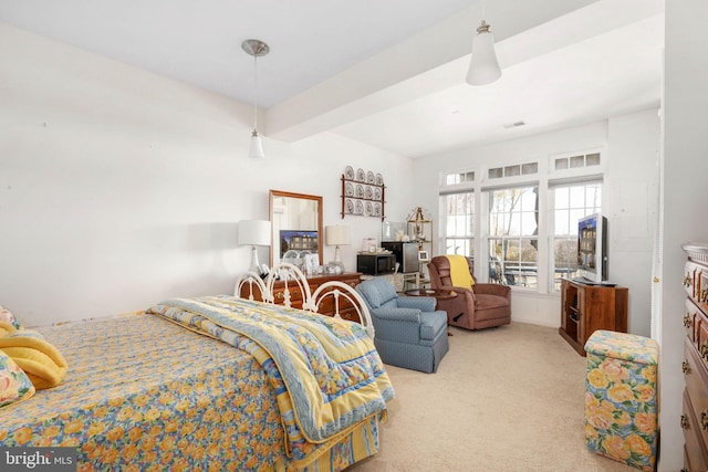 bedroom with beamed ceiling and light colored carpet