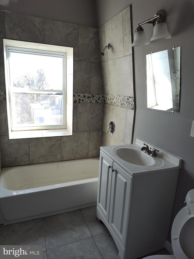 full bathroom featuring tile patterned flooring, vanity, tiled shower / bath combo, and toilet