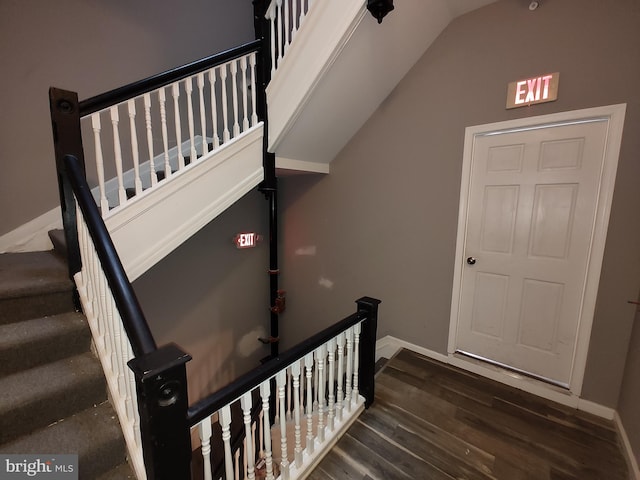 stairway featuring hardwood / wood-style flooring and vaulted ceiling