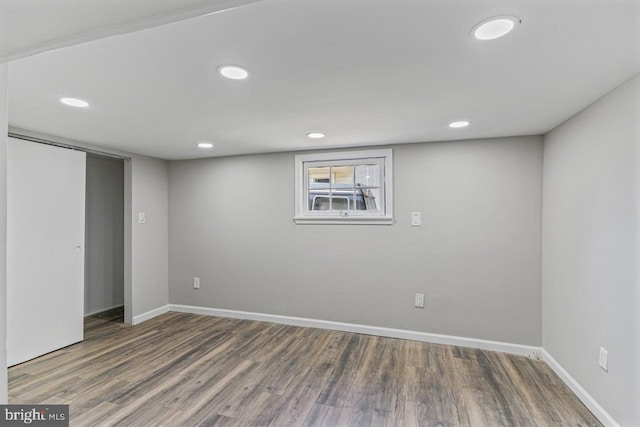 basement with dark hardwood / wood-style floors