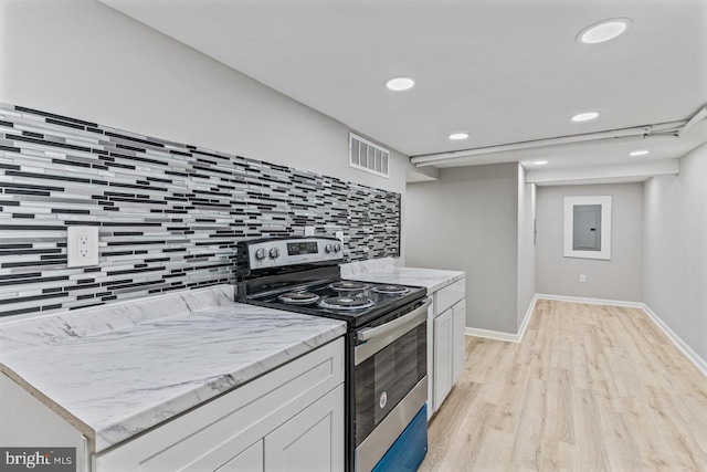 kitchen featuring tasteful backsplash, electric panel, light hardwood / wood-style floors, stainless steel electric range, and white cabinets