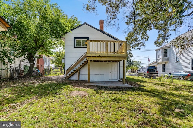 back of property featuring a deck and a yard