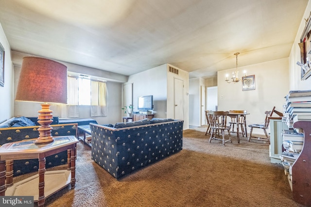 living room featuring dark colored carpet and an inviting chandelier