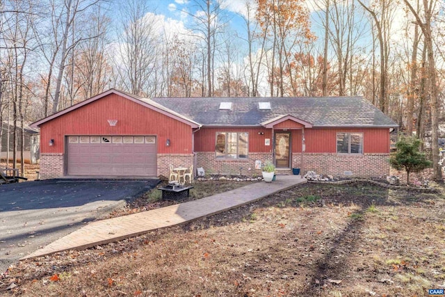 view of front of home featuring aphalt driveway, brick siding, and an attached garage