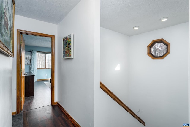 corridor featuring a textured ceiling and dark hardwood / wood-style floors