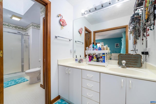 bathroom with a skylight, vanity, an enclosed shower, and toilet