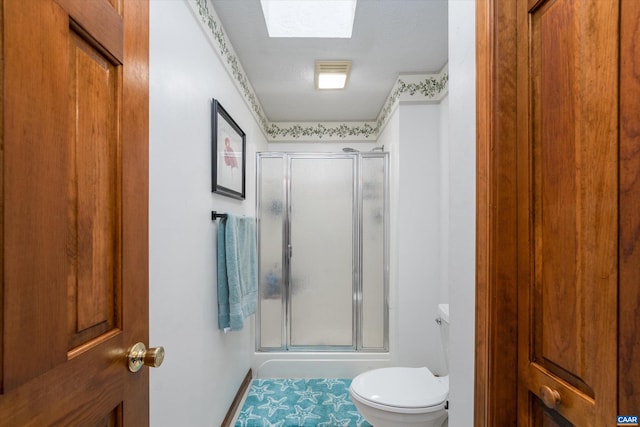 bathroom with a textured ceiling, a skylight, toilet, and walk in shower