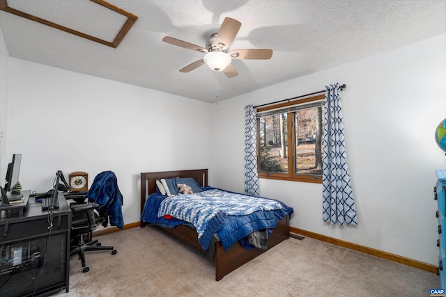 carpeted bedroom featuring ceiling fan and a textured ceiling