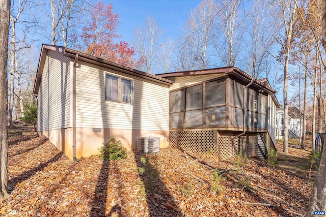 rear view of house featuring a sunroom and central AC