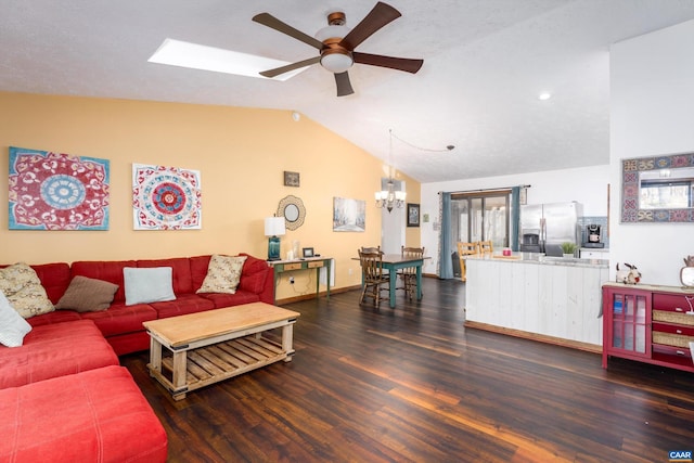 living room featuring ceiling fan with notable chandelier, dark hardwood / wood-style flooring, and vaulted ceiling with skylight