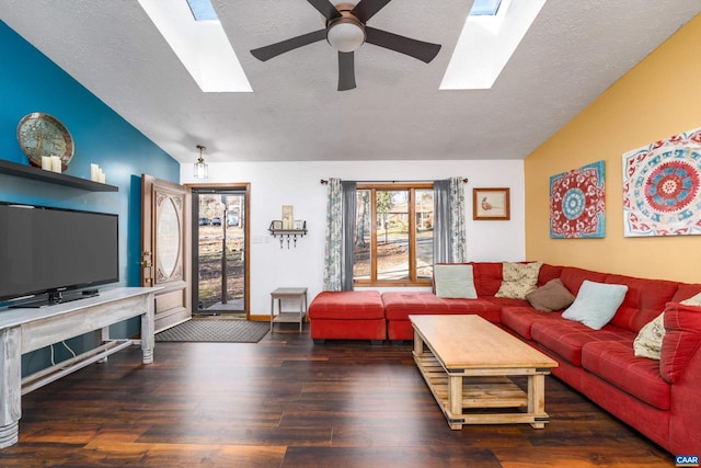 living room featuring dark hardwood / wood-style flooring, ceiling fan, and vaulted ceiling with skylight