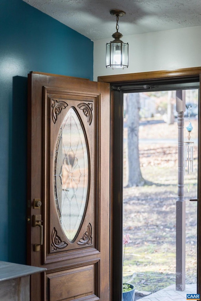 foyer entrance with a textured ceiling