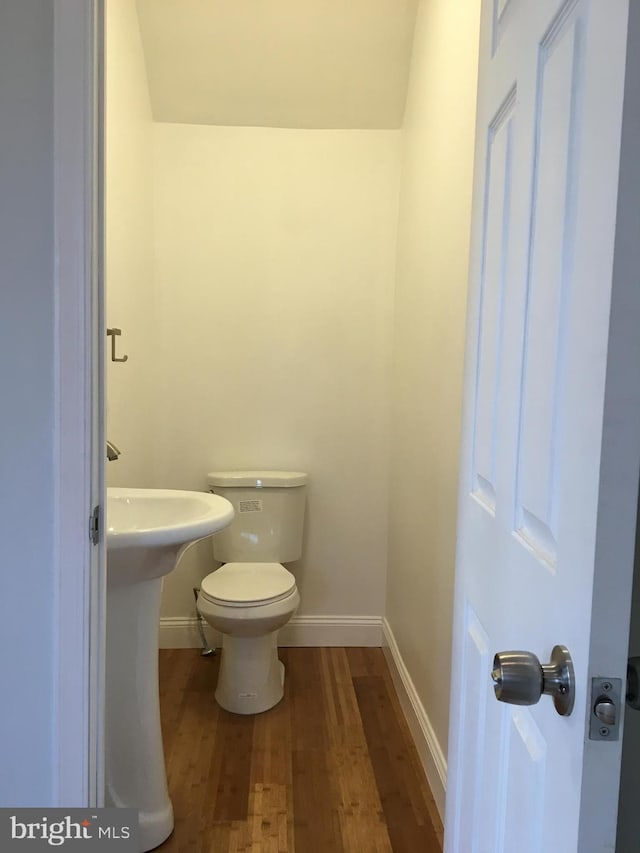 bathroom featuring hardwood / wood-style flooring and toilet