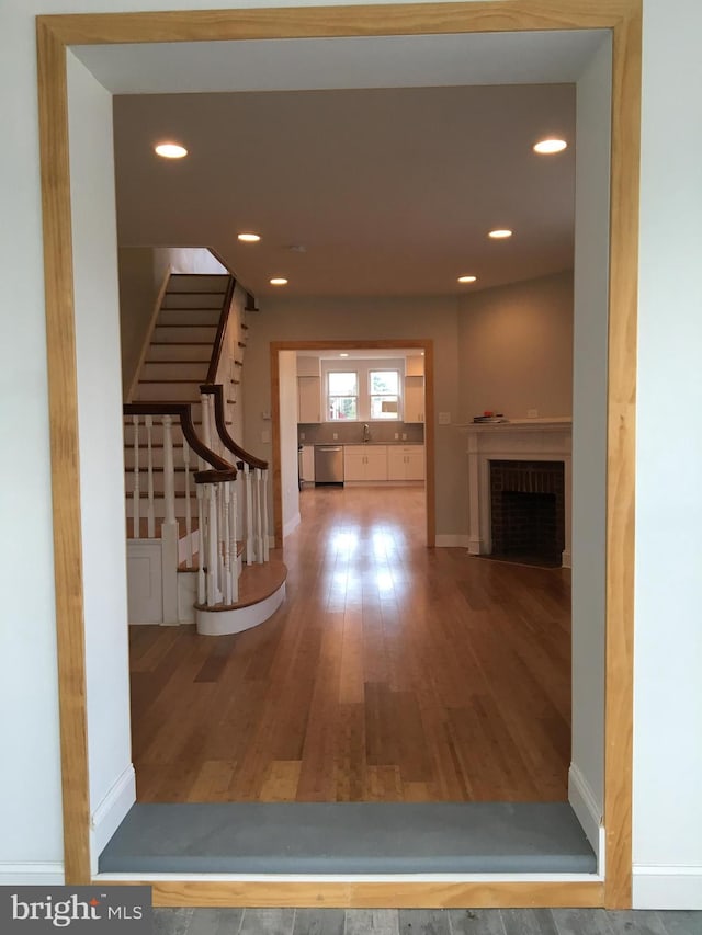 hallway with hardwood / wood-style flooring and sink