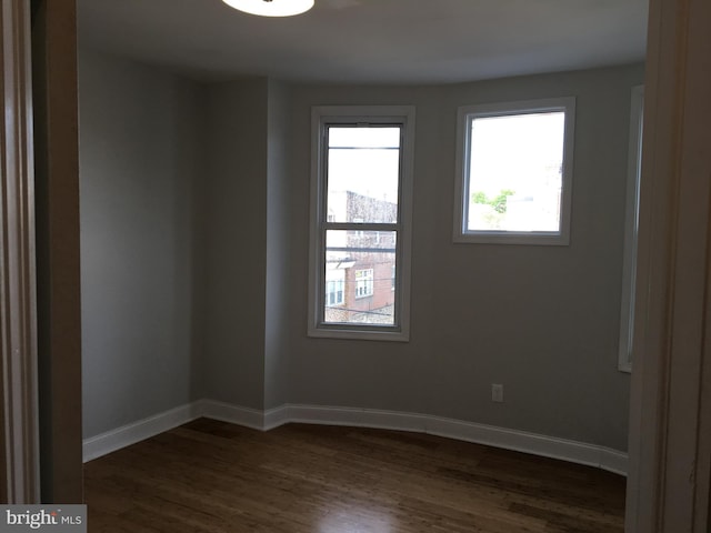 unfurnished room with dark hardwood / wood-style flooring