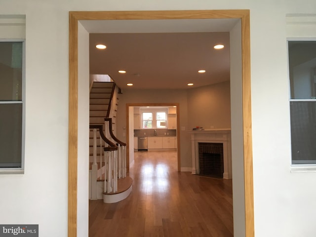 hallway with hardwood / wood-style floors and sink