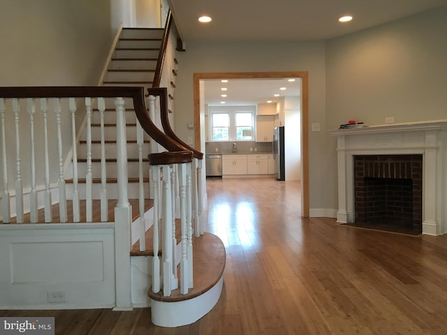 staircase with wood-type flooring and sink