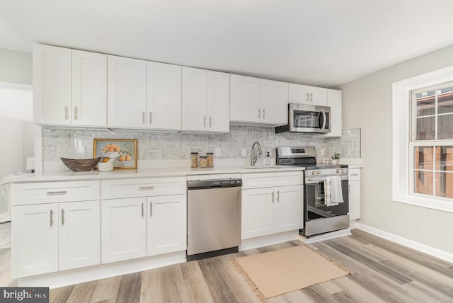 28 W Main St, Fairfield, PA 17320 - kitchen with stainless steel appliances, light wood-type flooring, backsplash, white cabinetry, and light countertops