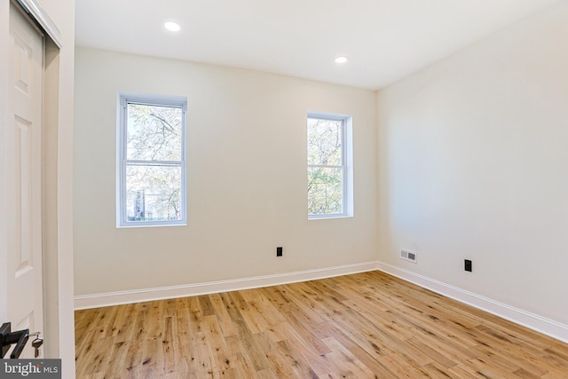 spare room with light hardwood / wood-style floors and a healthy amount of sunlight