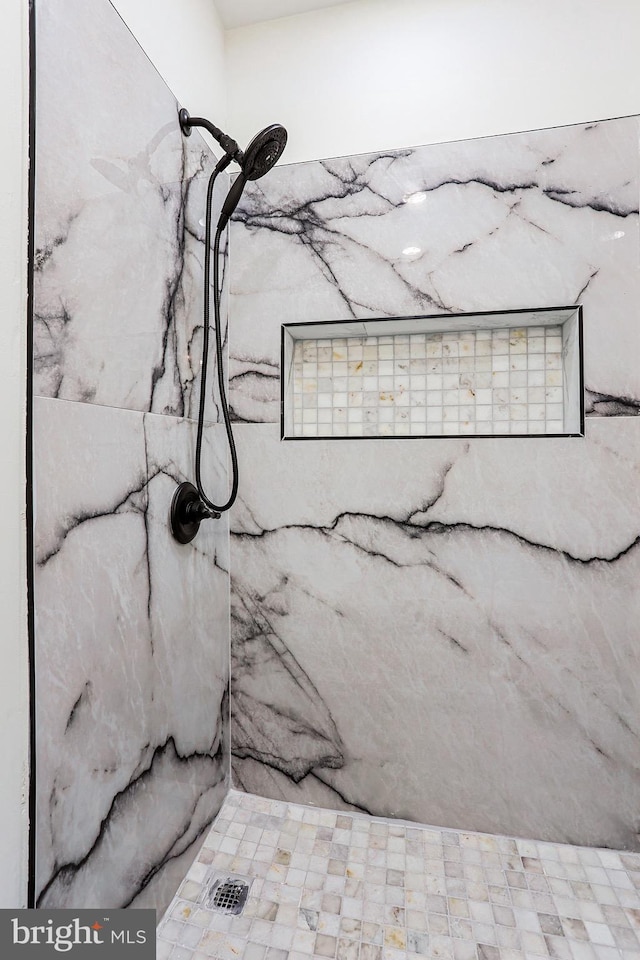 interior details featuring tiled shower