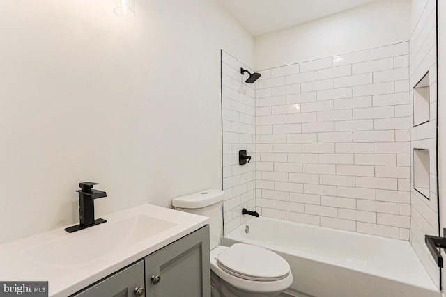 full bathroom with tiled shower / bath combo, toilet, and vanity