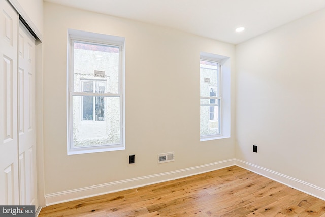 empty room featuring plenty of natural light and hardwood / wood-style floors