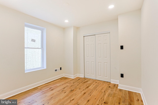 unfurnished bedroom featuring light wood-type flooring and a closet