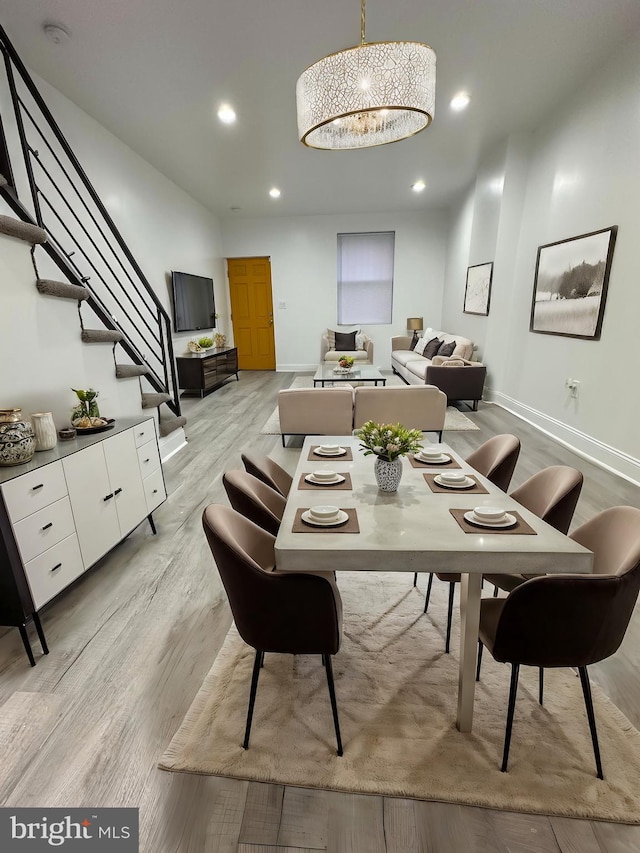 dining area featuring light hardwood / wood-style floors and a chandelier