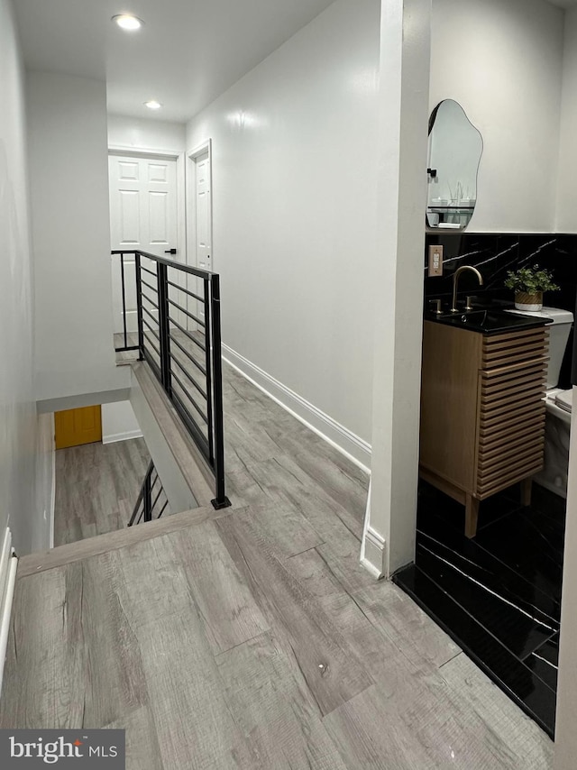 corridor featuring light hardwood / wood-style floors and sink