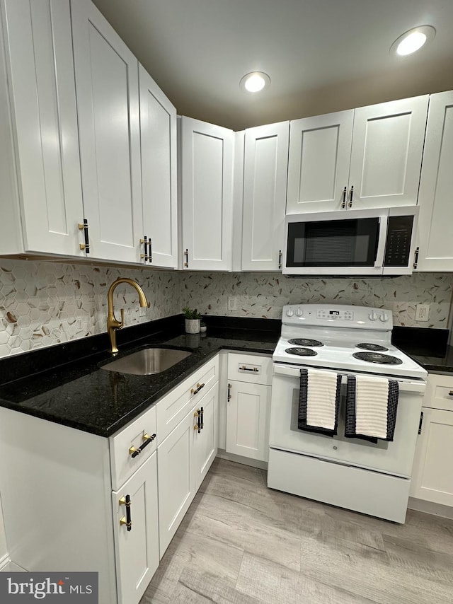 kitchen featuring white range with electric cooktop, sink, white cabinets, and light wood-type flooring