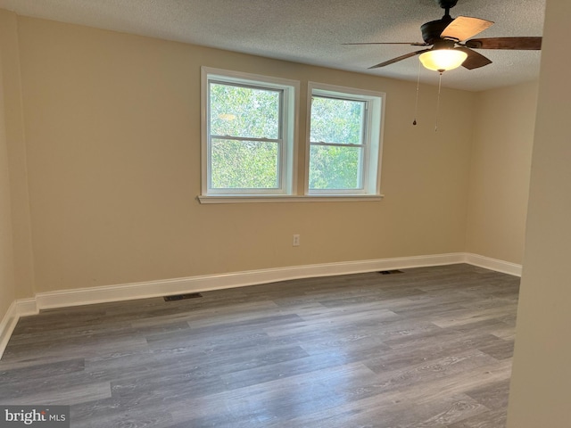 spare room with a textured ceiling, hardwood / wood-style flooring, and ceiling fan