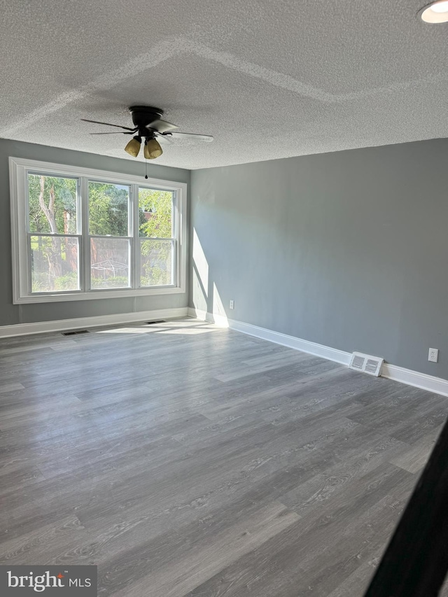 unfurnished room with ceiling fan, hardwood / wood-style floors, and a textured ceiling