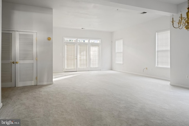 carpeted empty room with beam ceiling