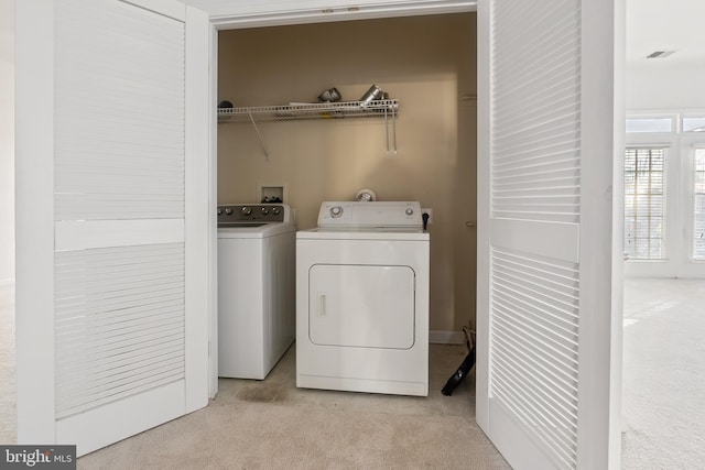 clothes washing area with washing machine and dryer and light colored carpet